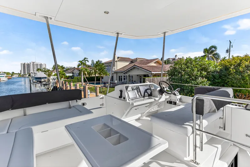  Yacht Photos Pics 2017 Leopard 43 Powercat cockpit with modern controls, docked near waterfront homes.