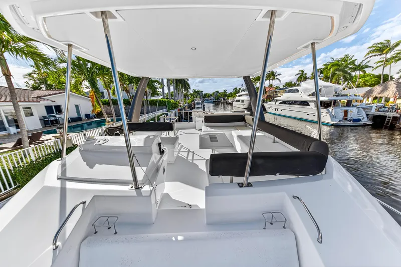  Yacht Photos Pics 2017 Leopard 43 Powercat yacht deck with seating, docked near waterfront homes and palm trees.