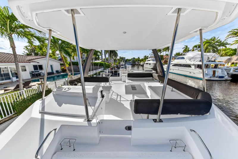  Yacht Photos Pics 2017 Leopard 43 Powercat yacht deck with seating, docked near waterfront homes and palm trees.