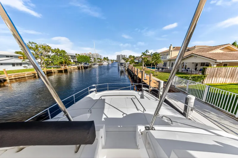  Yacht Photos Pics 2017 Leopard 43 Powercat on a scenic canal with waterfront homes.