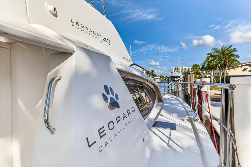  Yacht Photos Pics 2017 Leopard 43 Powercat docked, showcasing sleek design and branding under a clear blue sky.