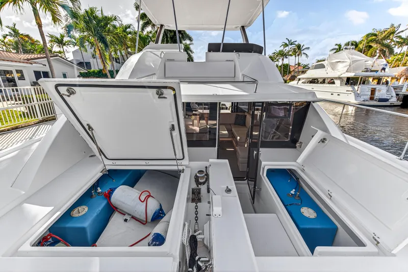  Yacht Photos Pics 2017 Leopard 43 Powercat yacht with open storage compartments, docked near palm trees.
