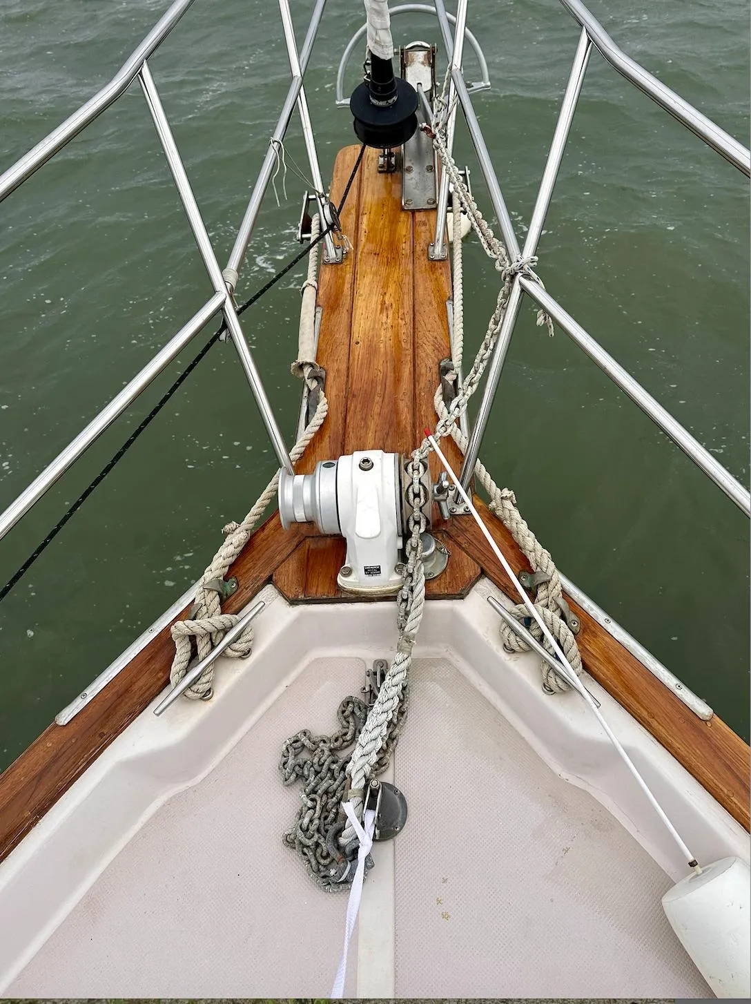 Bow of 1987 Island Packet 31 sailboat with anchor chain and teak deck.