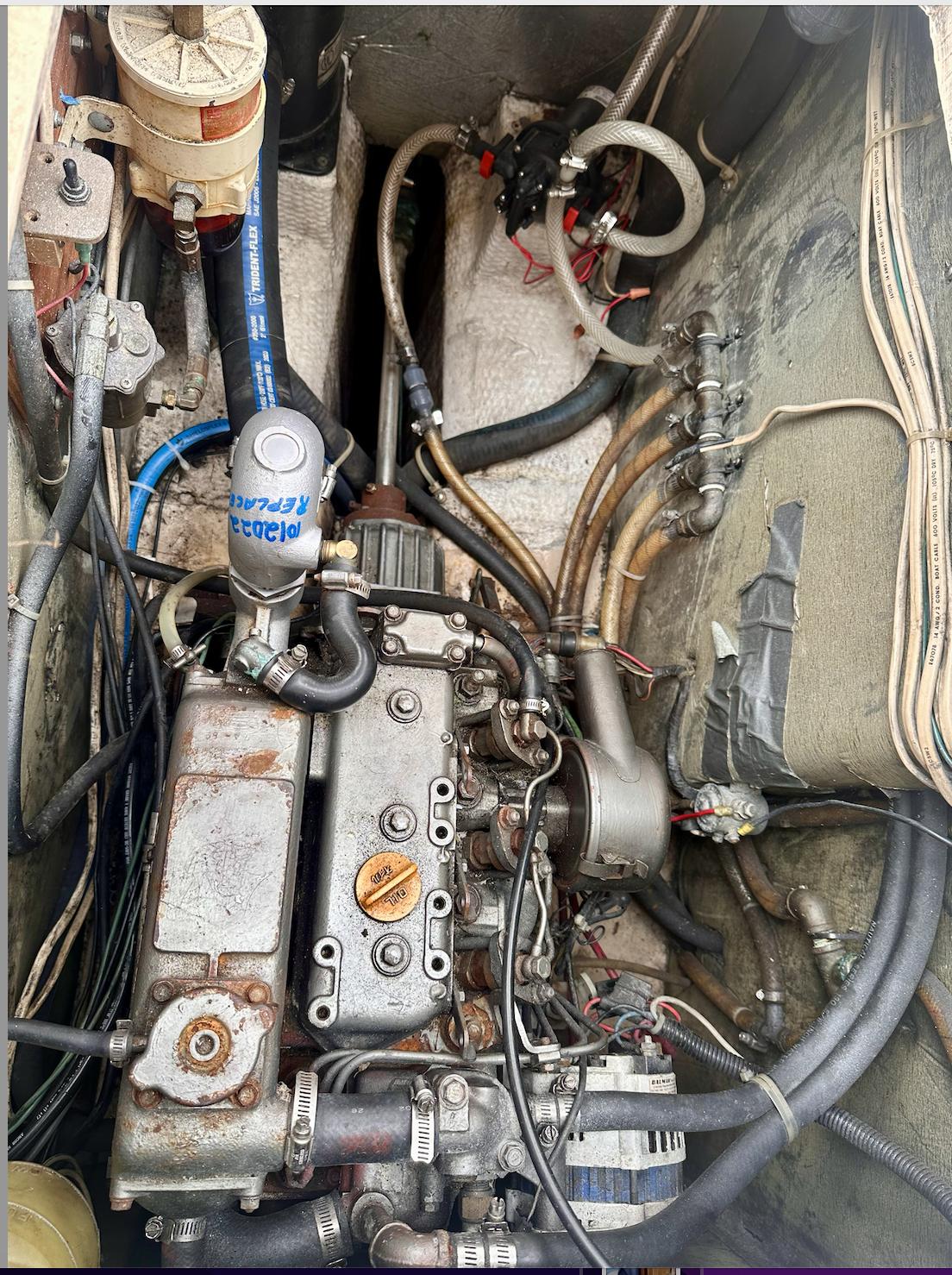 Engine compartment of a 1987 Island Packet 31 sailboat, showing mechanical components and wiring.