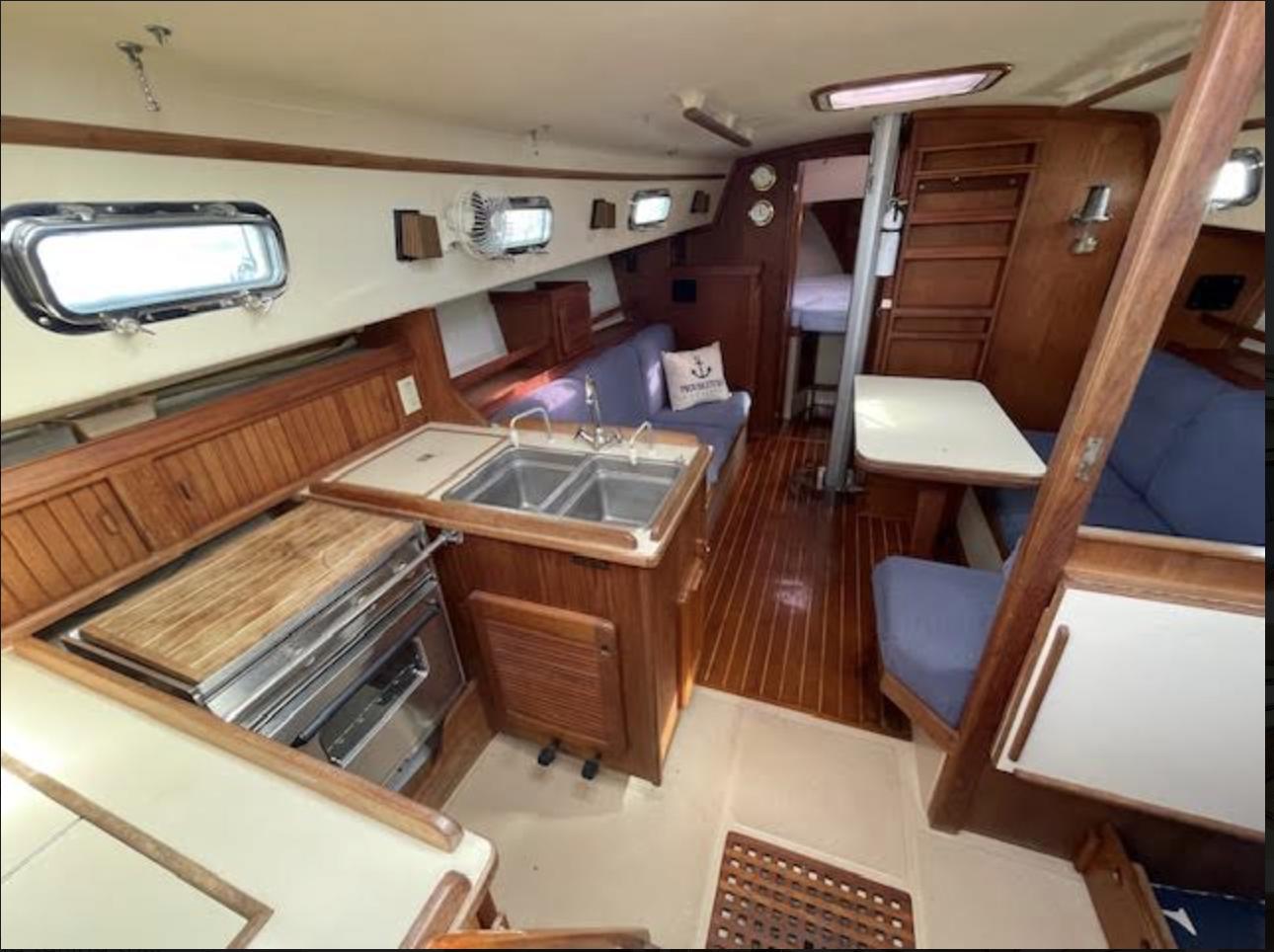 1987 Island Packet 31 yacht interior with kitchen, seating, and wood finishes.