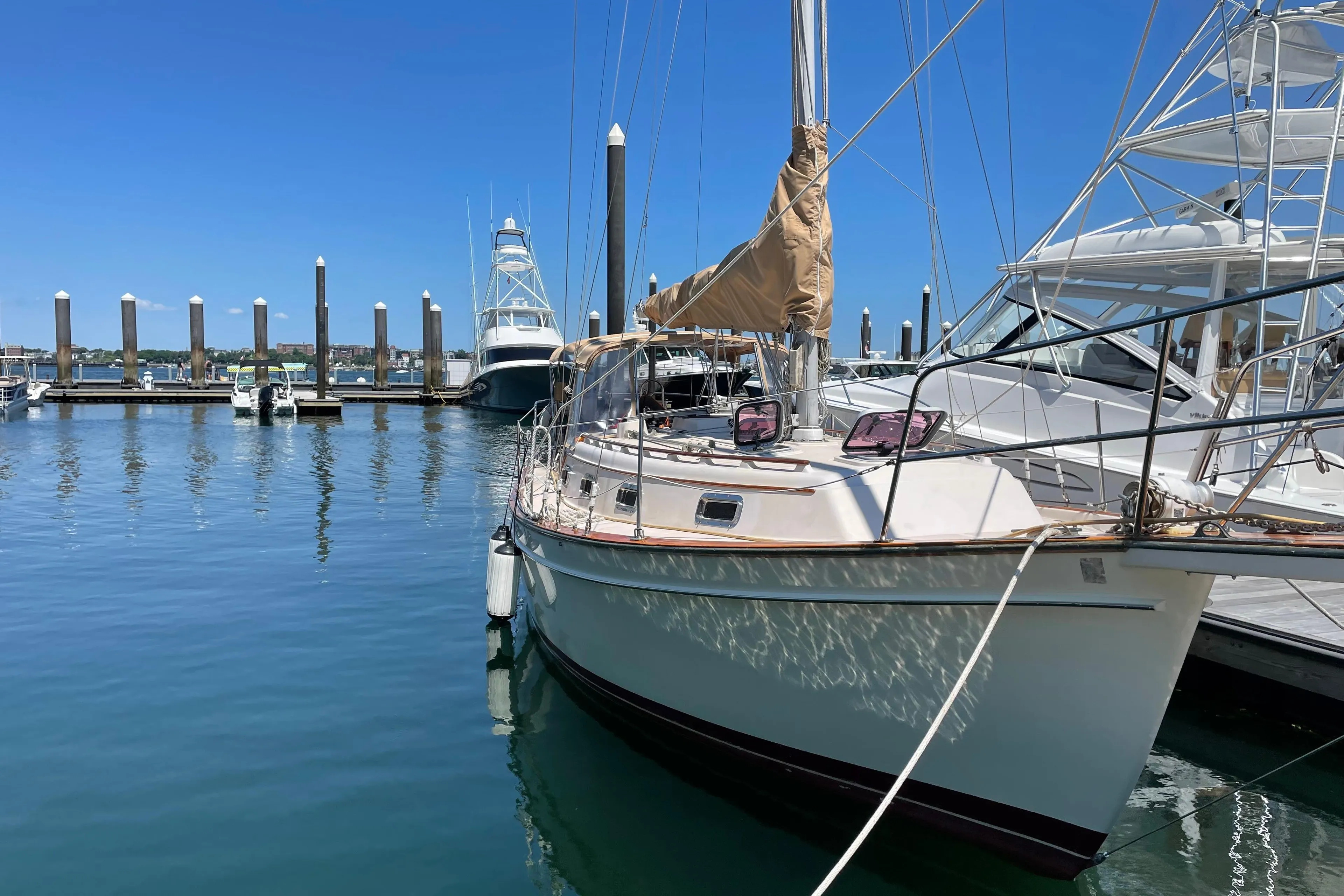 1987 Island Packet 31 sailboat docked at a marina under clear blue skies.