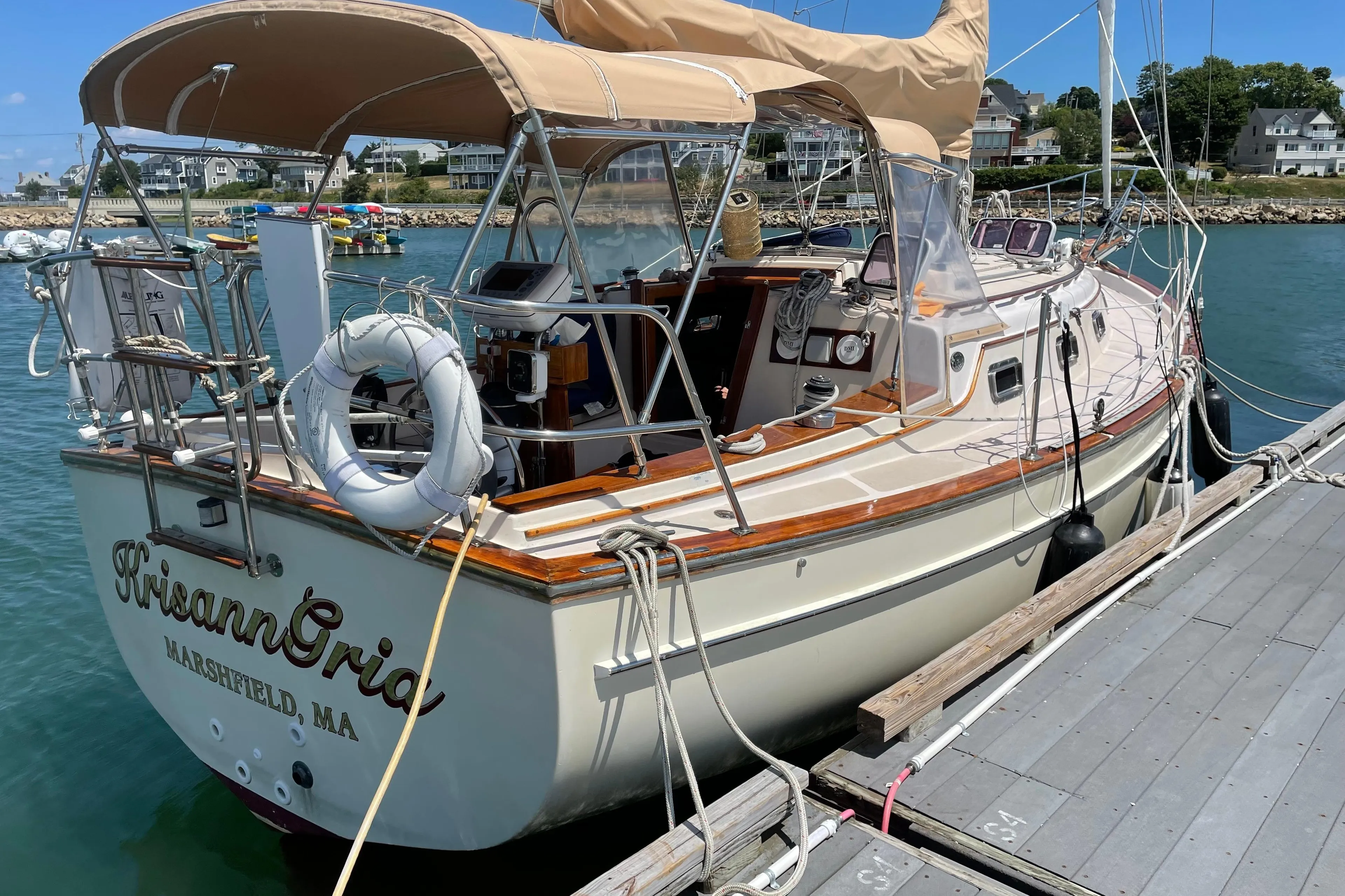 1987 Island Packet 31 sailboat docked, featuring tan canopy and wooden accents.