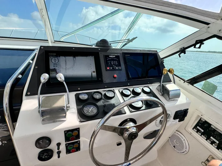 Island Time Yacht Photos Pics Control panel of a 1997 Bertram 36 Moppie boat with steering wheel and gauges.