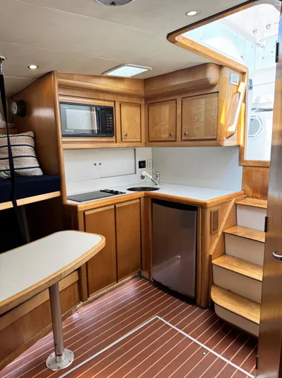Island Time Yacht Photos Pics Interior of a 1997 Bertram 36 Moppie yacht with wooden cabinetry and compact kitchen.