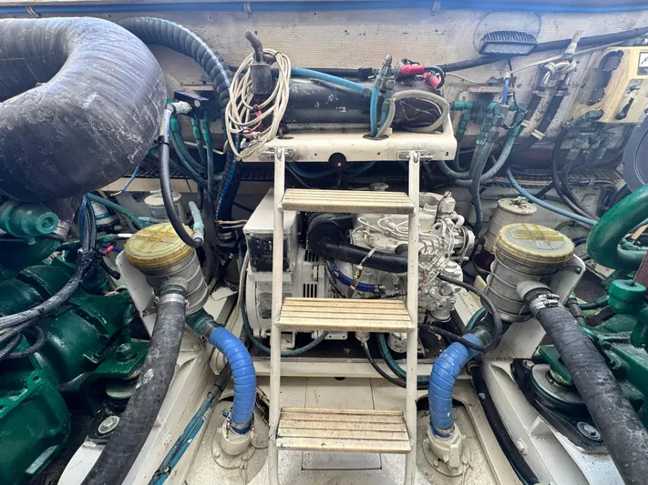 Island Time Yacht Photos Pics Engine room of a 1997 Bertram 36 Moppie boat, featuring complex machinery and hoses.