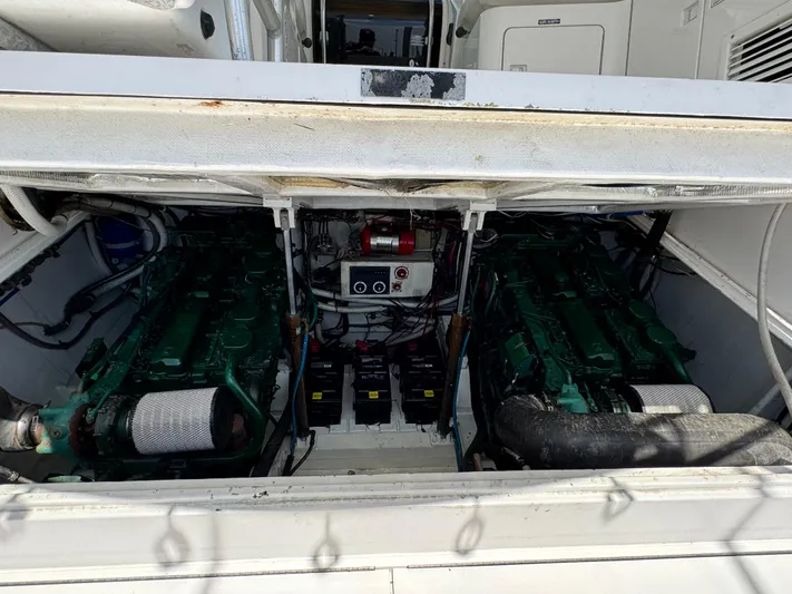 Island Time Yacht Photos Pics Engine compartment of a 1997 Bertram 36 Moppie, showcasing dual green engines and battery setup.