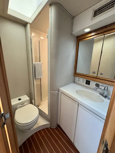 Island Time Yacht Photos Pics Bathroom interior of 1997 Bertram 36 Moppie yacht with shower, toilet, and sink.