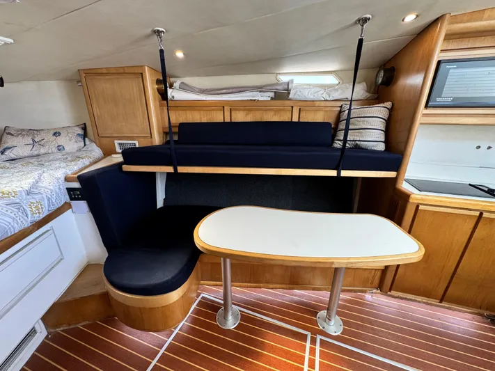 Island Time Yacht Photos Pics 1997 Bertram 36 Moppie interior with wooden cabinetry, seating, and table.