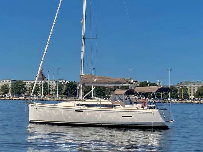 Glide Away Yacht Photos Pics 2015 Jeanneau Sun Odyssey 379 sailboat on calm water, clear blue sky background.