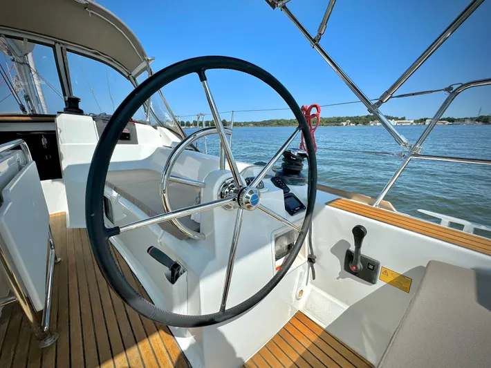 Glide Away Yacht Photos Pics Steering wheel of 2015 Jeanneau Sun Odyssey 379 sailboat on calm water.