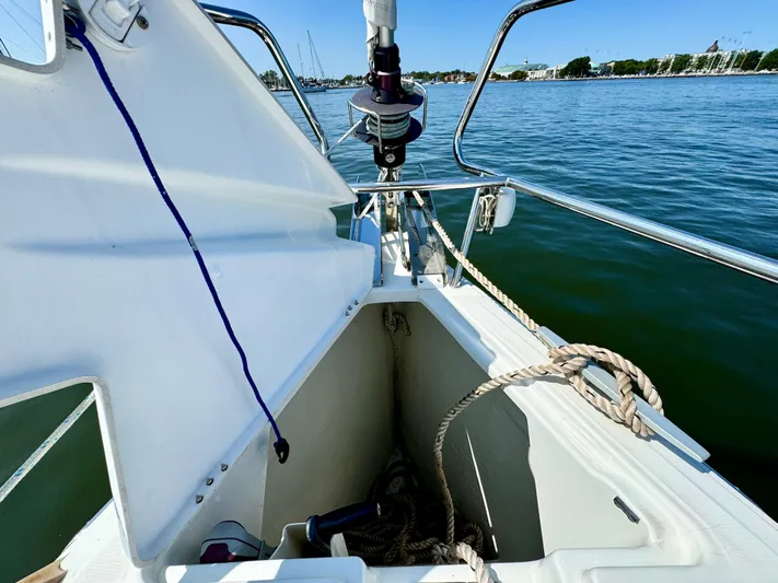 Glide Away Yacht Photos Pics 2015 Jeanneau Sun Odyssey 379 sailboat anchor locker with ropes, docked on calm water.