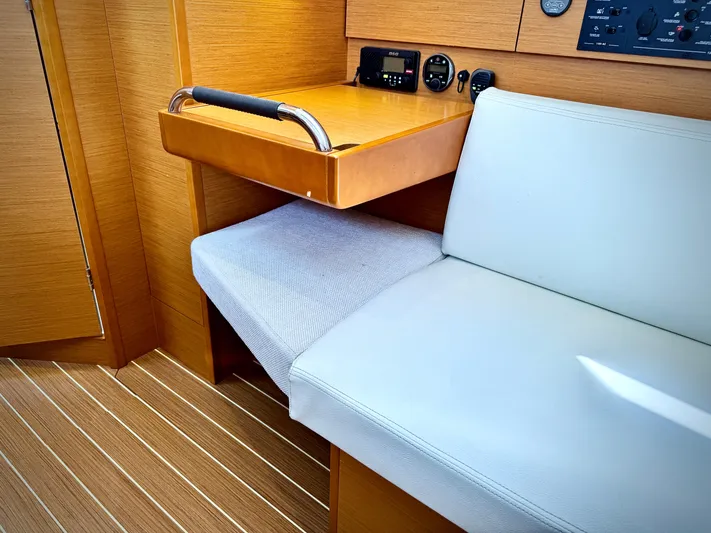 Glide Away Yacht Photos Pics Interior of 2015 Jeanneau Sun Odyssey 379 yacht with seating and navigation station.