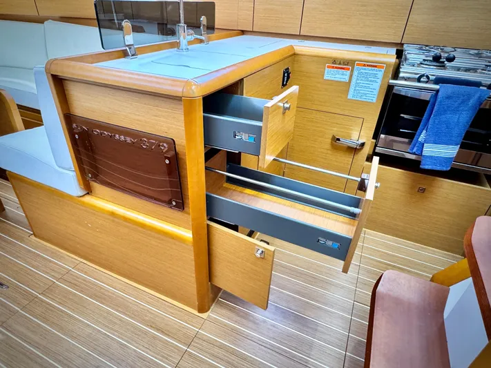 Glide Away Yacht Photos Pics Interior of 2015 Jeanneau Sun Odyssey 379 yacht with open drawers and modern kitchen.