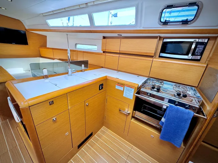 Glide Away Yacht Photos Pics Modern kitchen interior of 2015 Jeanneau Sun Odyssey 379 sailboat with wood cabinetry.