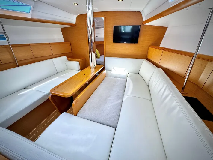 Glide Away Yacht Photos Pics Interior of 2015 Jeanneau Sun Odyssey 379 yacht with white seating and wooden accents.