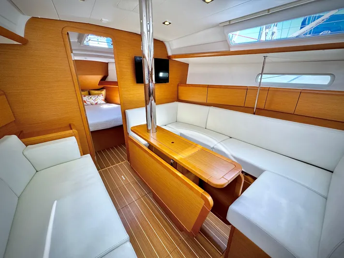 Glide Away Yacht Photos Pics Interior of 2015 Jeanneau Sun Odyssey 379 sailboat with modern wood and white seating.