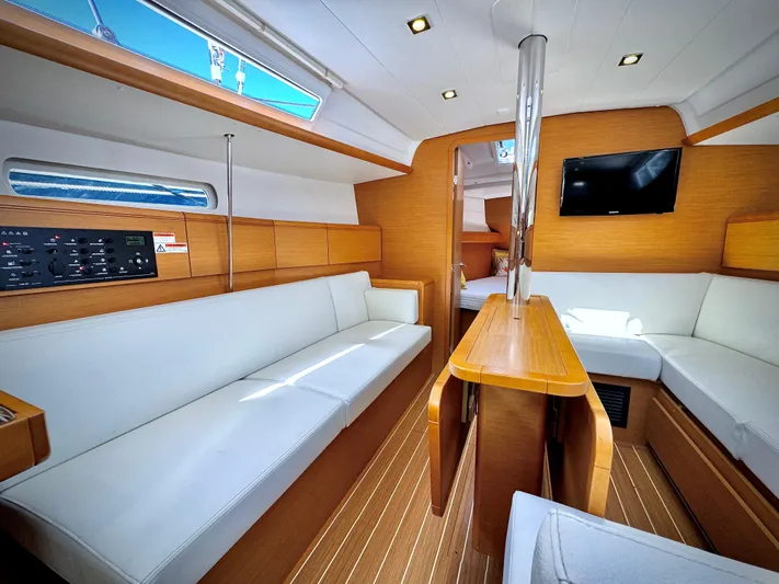 Glide Away Yacht Photos Pics Interior of 2015 Jeanneau Sun Odyssey 379 sailboat with modern wood finish and white seating.