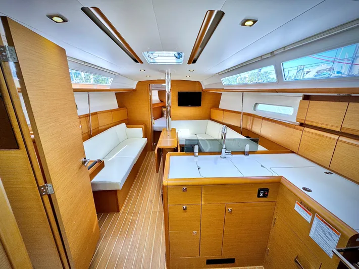 Glide Away Yacht Photos Pics Interior of 2015 Jeanneau Sun Odyssey 379 sailboat, featuring modern wood finish and spacious layout.