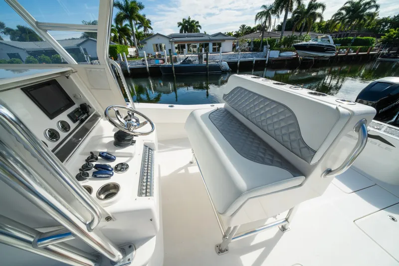 Carried Away Yacht Photos Pics 2016 Invincible 36 Open Fisherman boat interior with steering console and seating, docked by waterfront homes.