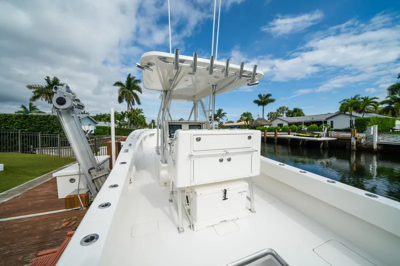 Carried Away Yacht Photos Pics 2016 Invincible 36 Open Fisherman boat docked by a canal, under a clear blue sky.
