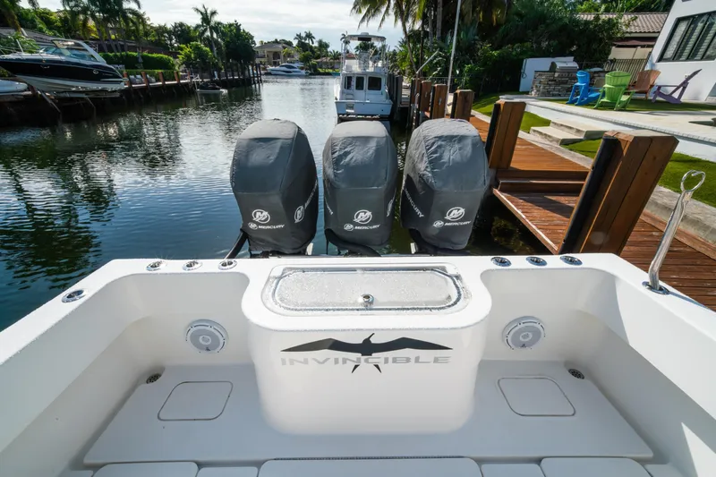 Carried Away Yacht Photos Pics 2016 Invincible 36 Open Fisherman with triple Mercury engines docked in a scenic canal.