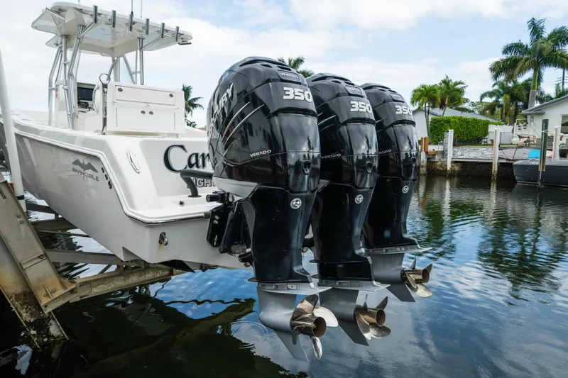 Carried Away Yacht Photos Pics 2016 Invincible 36 Open Fisherman with triple Mercury 350 engines docked by palm trees.