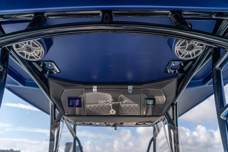 Work From Home Yacht Photos Pics 2024 Nor-Tech 390 Sport boat console with speakers and blue canopy.