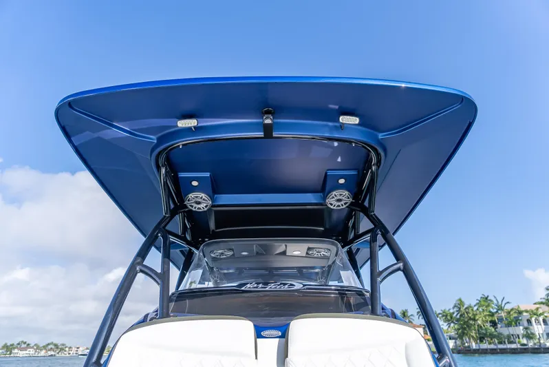 Work From Home Yacht Photos Pics 2024 Nor-Tech 390 Sport boat with sleek blue canopy and modern design.