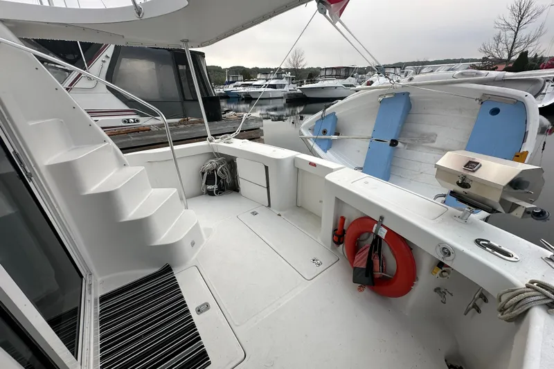Lucky Dog Yacht Photos Pics 2002 Mainship 390 Trawler deck with stairs, lifebuoy, and docked boats in background.