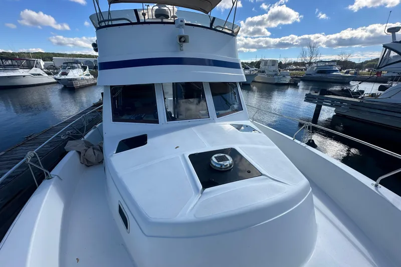 Lucky Dog Yacht Photos Pics 2002 Mainship 390 Trawler docked at a marina under a blue sky.
