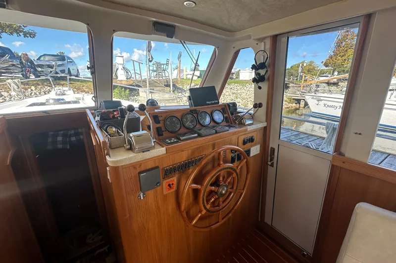 Lucky Dog Yacht Photos Pics 2002 Mainship 390 Trawler helm with wooden steering wheel and navigation instruments.