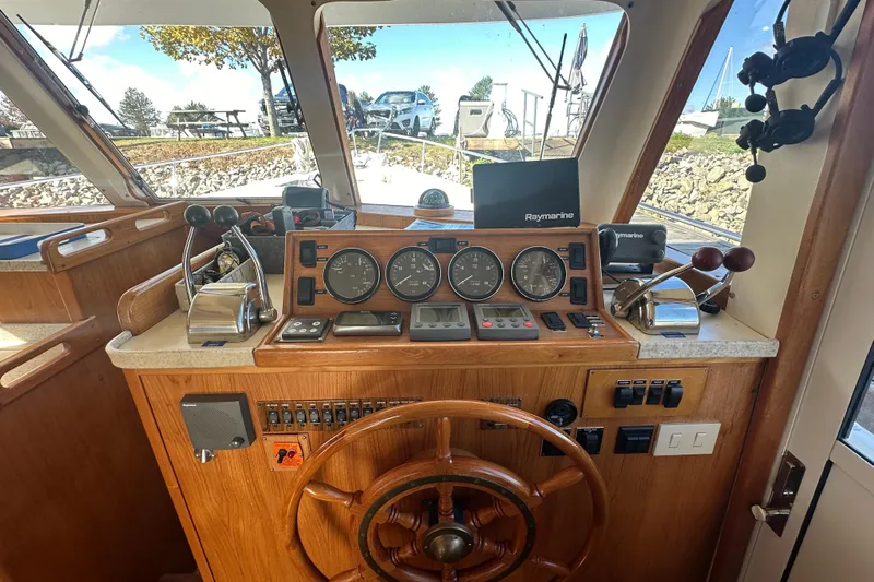 Lucky Dog Yacht Photos Pics 2002 Mainship 390 Trawler helm with gauges, controls, and Raymarine navigation system.