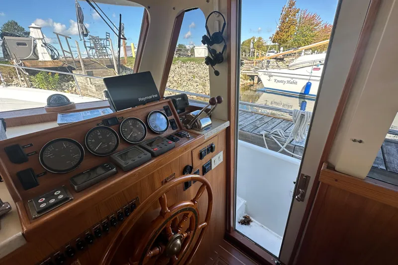 Lucky Dog Yacht Photos Pics 2002 Mainship 390 Trawler helm with gauges, steering wheel, and Raymarine equipment.