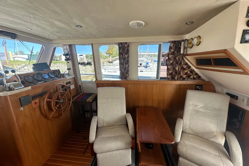 Lucky Dog Yacht Photos Pics 2002 Mainship 390 Trawler interior with helm, wooden accents, and comfortable seating.