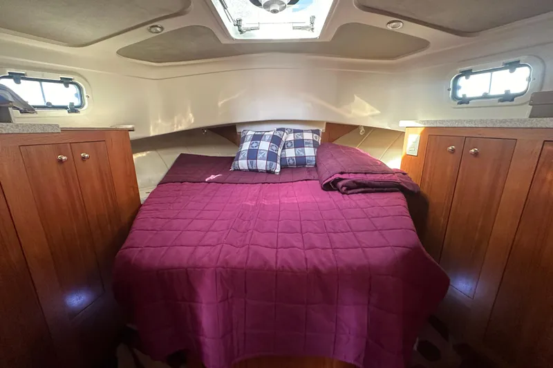 Lucky Dog Yacht Photos Pics 2002 Mainship 390 Trawler cabin with cozy bed, wooden cabinets, and natural light.
