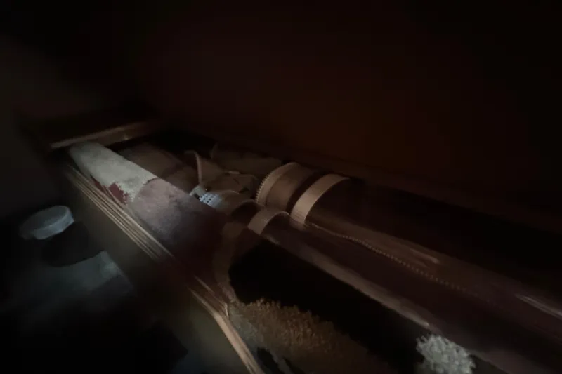 Lucky Dog Yacht Photos Pics Dark storage area inside 2002 Mainship 390 Trawler, featuring rolled-up items and dim lighting.