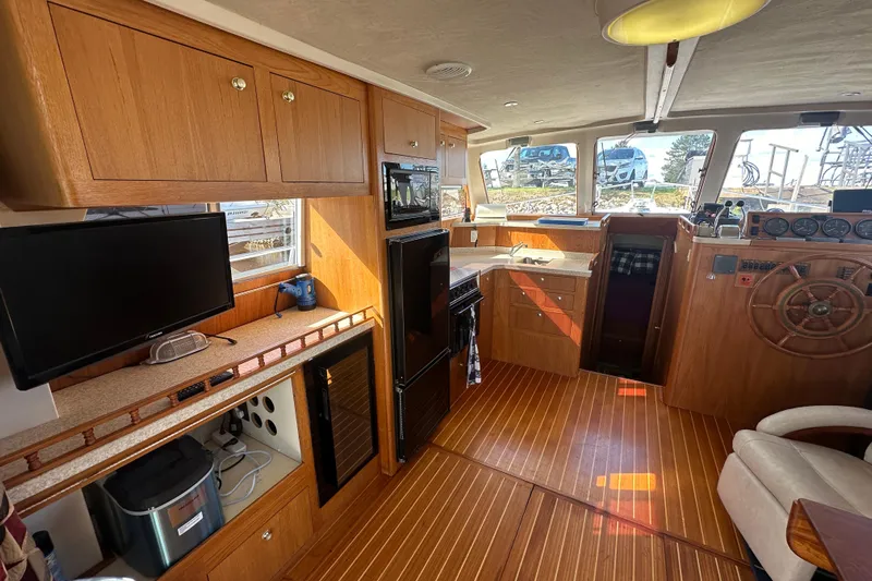 Lucky Dog Yacht Photos Pics Interior of 2002 Mainship 390 Trawler with wood finish, kitchen, and helm station.