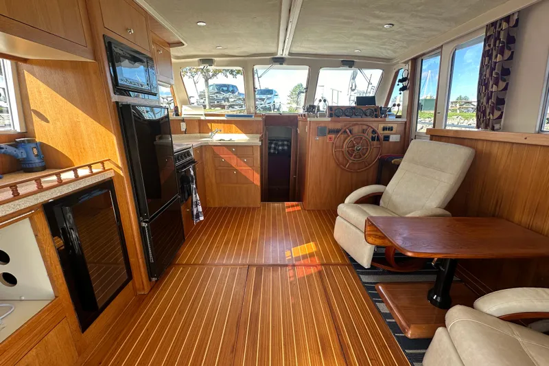 Lucky Dog Yacht Photos Pics 2002 Mainship 390 Trawler interior with wood finish, helm, and seating area.