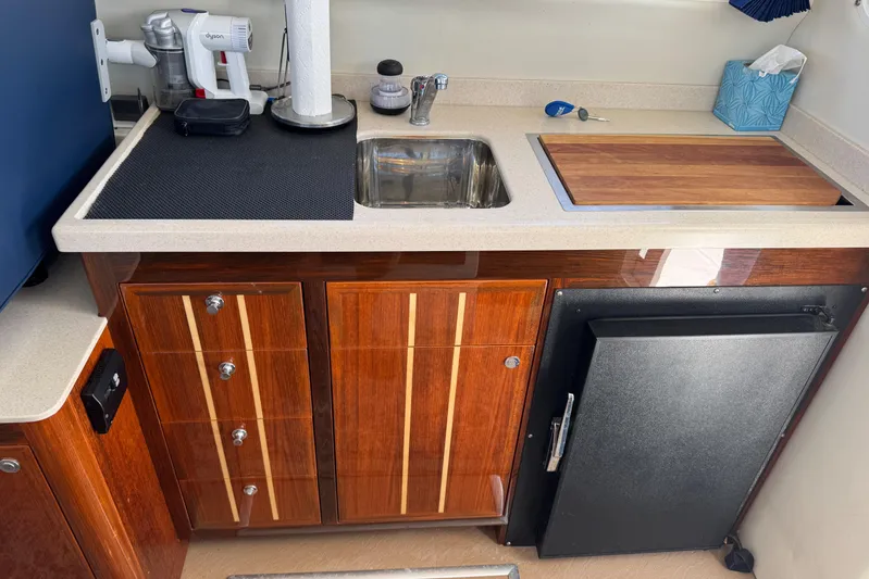  Yacht Photos Pics Compact kitchen area in a 2010 Ocean Sport Roamer boat with wooden cabinetry and sink.