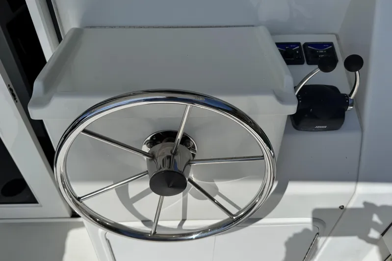  Yacht Photos Pics Steering wheel of a 2010 Ocean Sport Roamer boat, featuring chrome details and control levers.