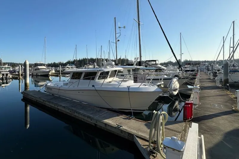  Yacht Photos Pics Ocean Sport Roamer 2010 docked at marina, surrounded by other boats under clear blue sky.