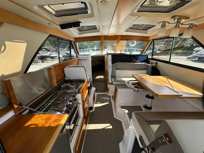  Yacht Photos Pics Interior of 2018 Cutwater C-302 Coupe boat with kitchen and seating area.