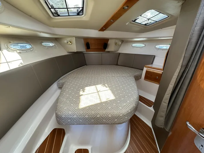  Yacht Photos Pics 2018 Cutwater C-302 Coupe cabin interior with bed, portholes, and wood accents.