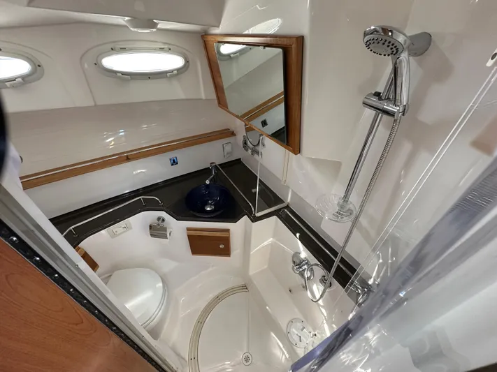  Yacht Photos Pics 2018 Cutwater C-302 Coupe bathroom with shower, sink, and toilet in compact, modern design.