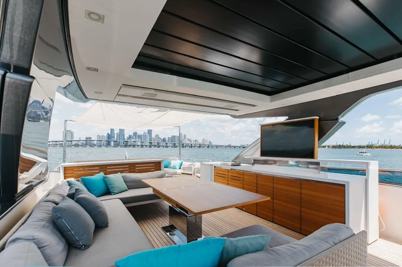 Sasa Yacht Photos Pics Luxurious 2022 Sanlorenzo SL86 yacht deck with city skyline view, featuring plush seating and a TV.